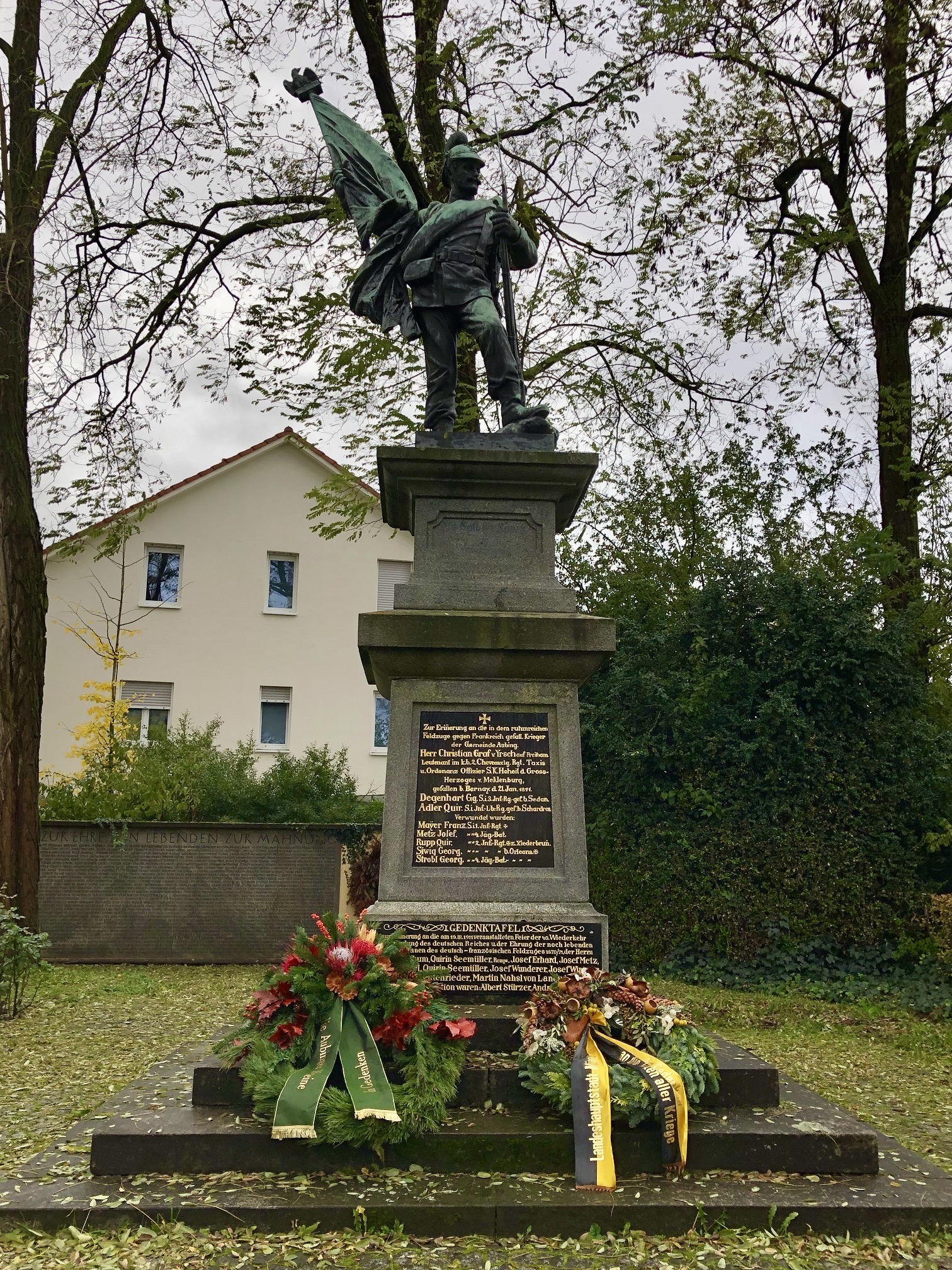 Das Aubinger Kriegerdenkmal mit dem Kranz der Stadt München (rechts) und dem der Arge der Aubing-Neuaubinger Vereine (links).