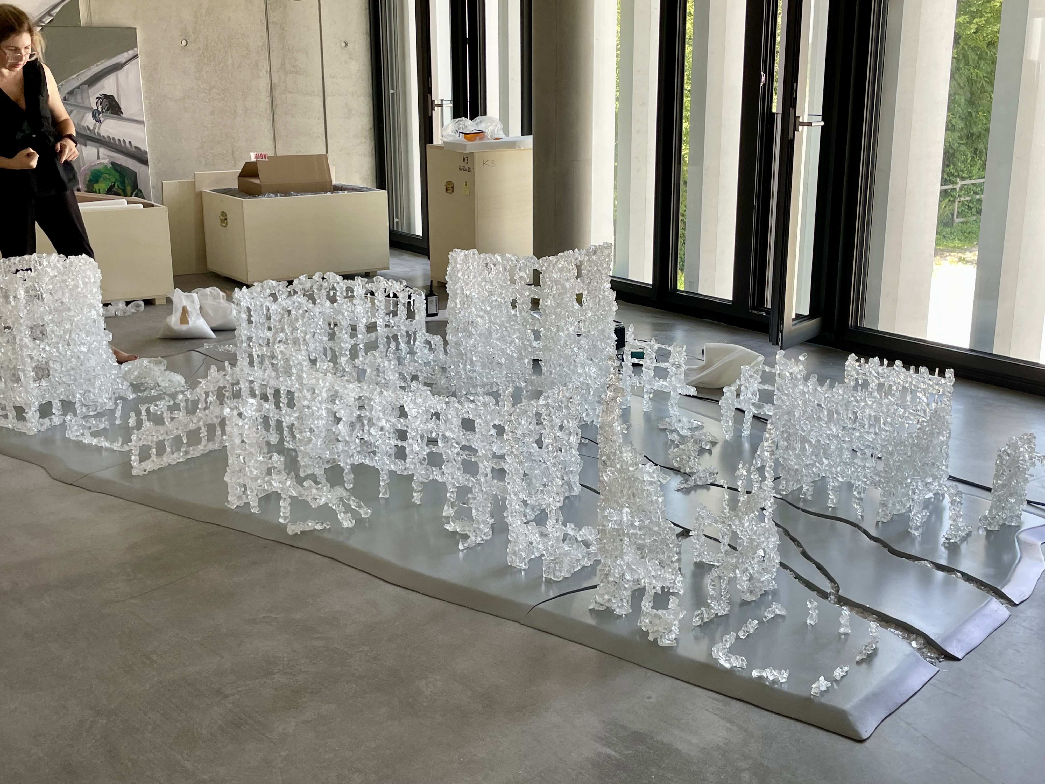 Die großformatige Installation aus Muranoglas von Marya Kazouns bildet die Landschaft einer nicht genannten zerstörten und eingefrorenen Stadt nach.