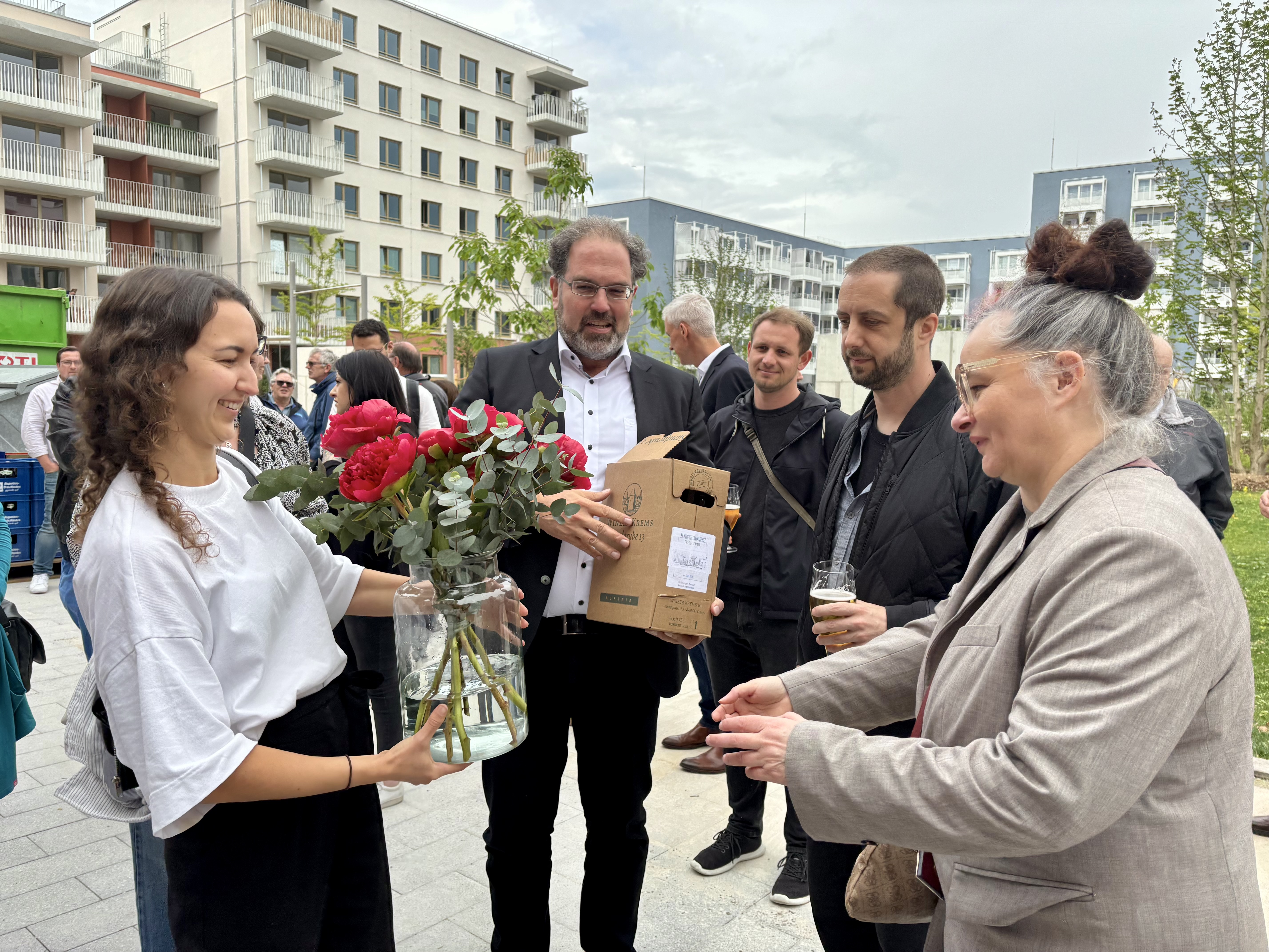 Blumen und Wein fürs Fertigstellungsfest an Projektleiterin Julie Kleinke (r.) von Oksana Tchyslovska, Martin Pfeiffer und Philipp Wemmer (v.l.) vom Architektenteam.