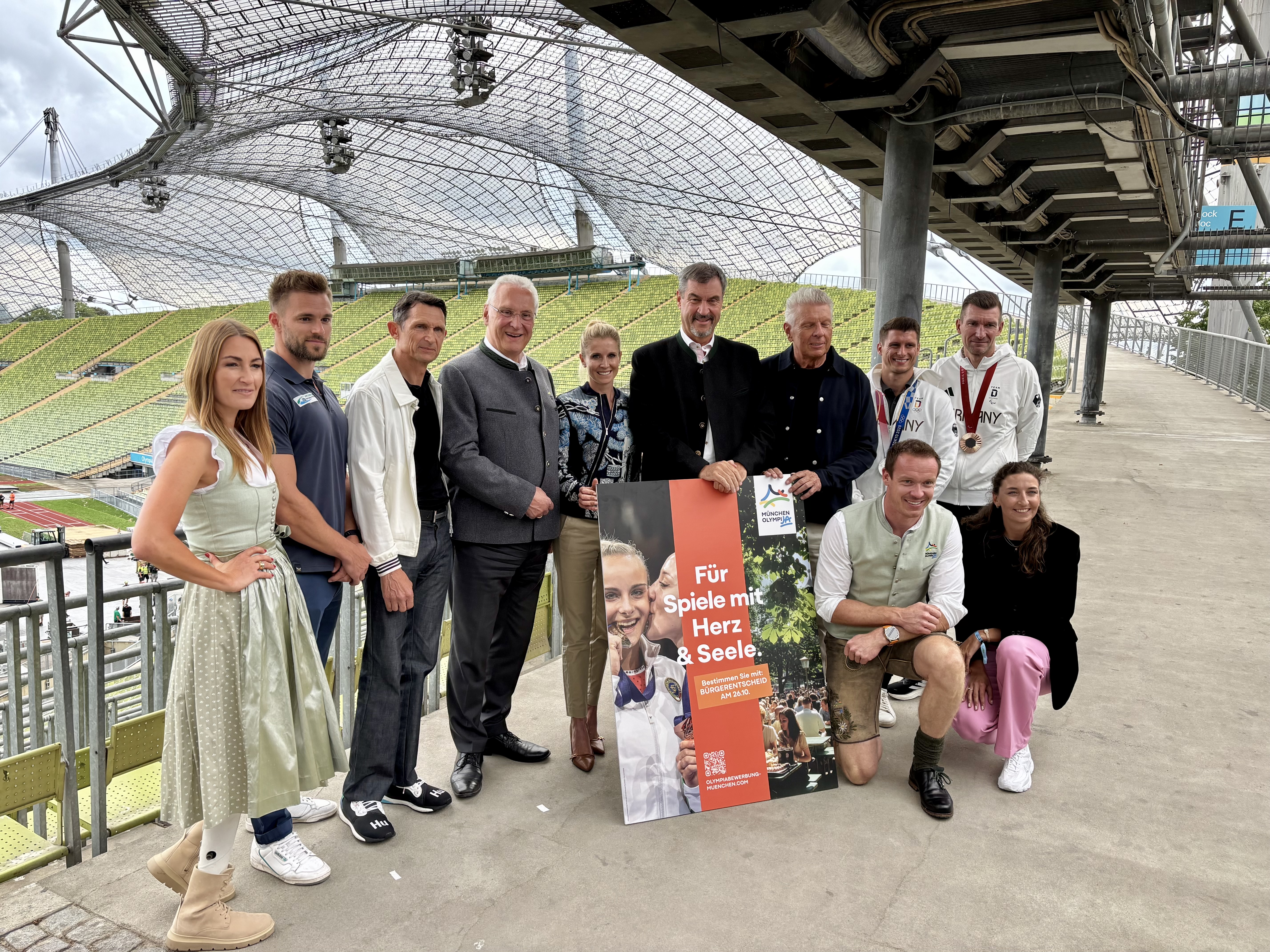 „Für Spiele mit Herz" werben Politiker und Sportler (hinten von links): Denise Schindler, Lukas Dauser, Michael Teuber, Sportminister Joachim Hermann, Jessica von Bredow-Werndl, Ministerpräsident Markus Söder, OB Dieter Reiter, Matthias Schindler, Tobias Schneider sowie (vorn v.l.) Felix Loch und Christina Hering.